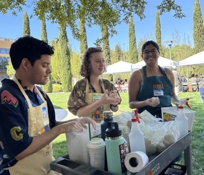 Three students preparing clay for children's art activity.