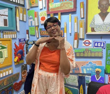 Woman in a brightly colored gallery space in Brazil posing for the camera
