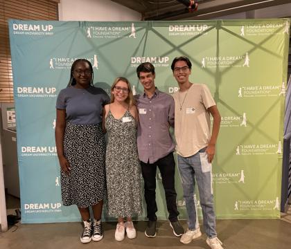 Four Summer 2022 Education Achievement Fellows posing in front of a "I Have a Dream" Foundation backdrop