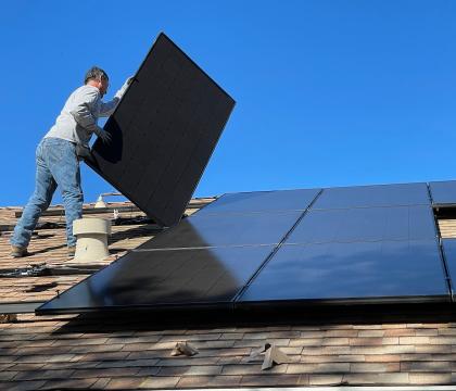 Worker installing rooftop solar panels