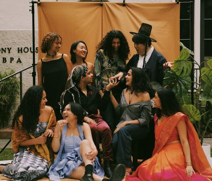 Group of students in bright colors laughing in front of the Harmony House