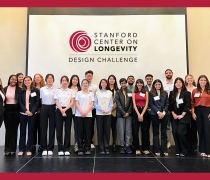 A group of students, all Finalists in the 2023 Longevity Design Challenge, pose for a picture on a stage.