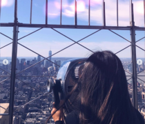 A student looks out at the rooftops of NYC from an observation deck.