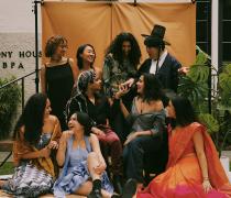 Group of students in bright colors laughing in front of the Harmony House